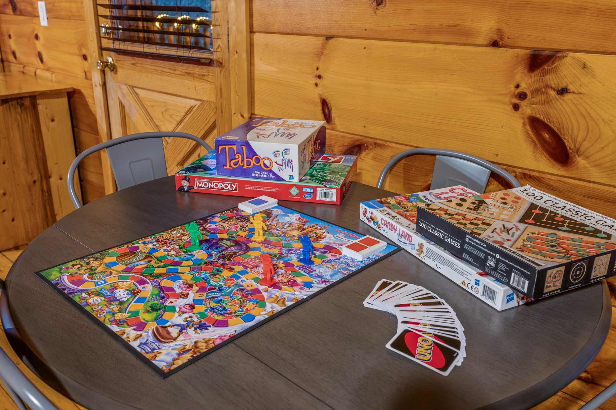 Board games including Taboo, Monopoly, and Candy Land set out on a table in Bearadise's bunk room
